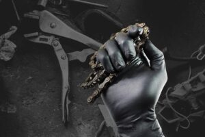 Black Nitrile Glove holding chain with dark garage background