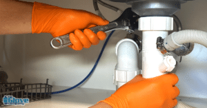 Plumbers fixing pipes wearing TGC Orange Hi-Vis Nitrile Disposable Gloves