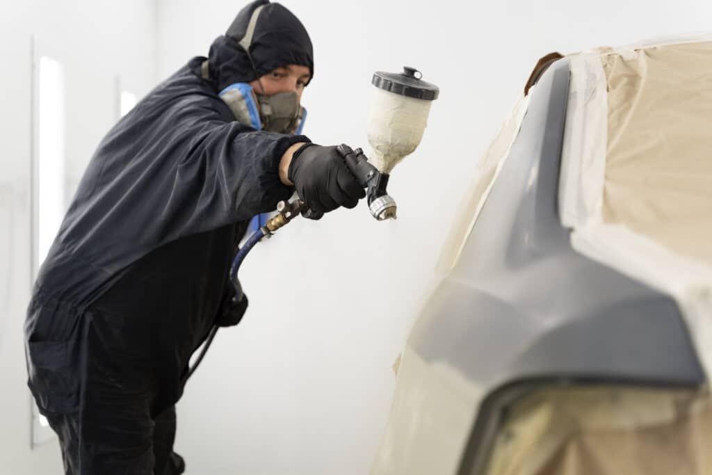 Man using TGC Black Nitrile gloves to spray coat a car